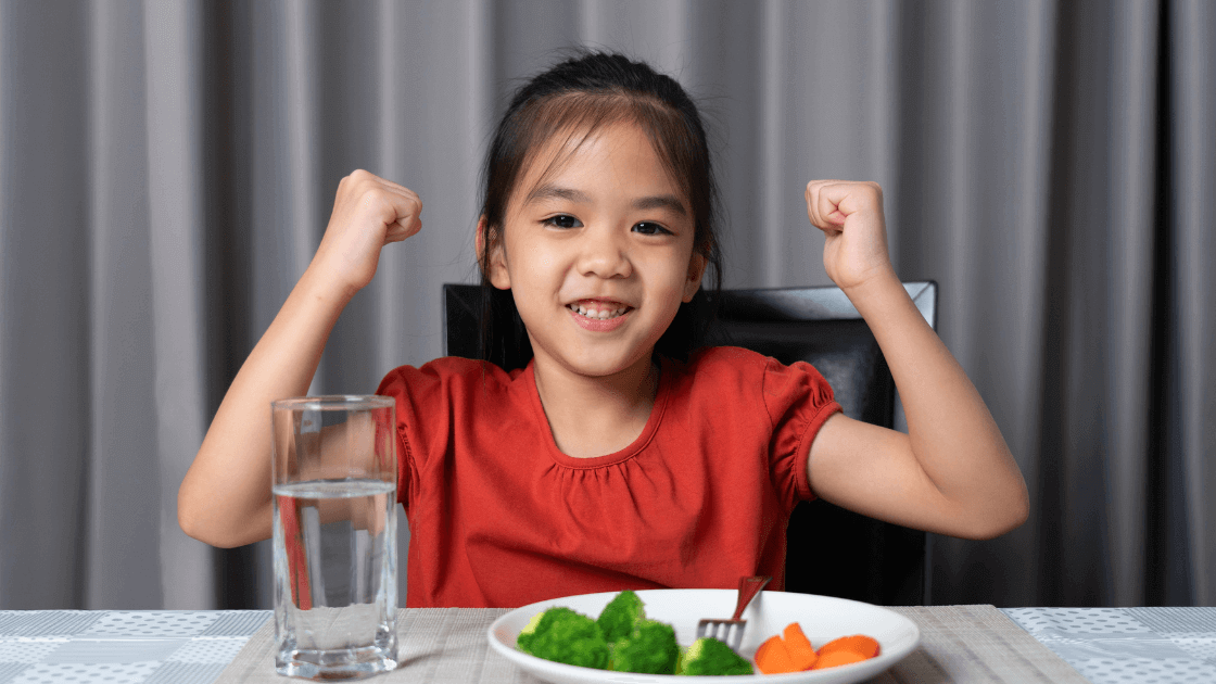 Child eating a high-fiber meal including fruits, vegetables, and whole grains